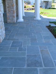 a stone walkway between two white pillars