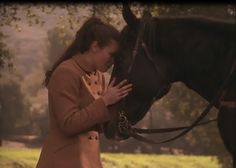 a woman standing next to a black horse