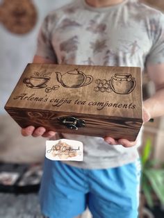 a man is holding a wooden box with writing on it that says, there's coffee and tea components