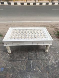 a white coffee table sitting on the side of a road next to a street sign