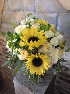 a vase filled with white and yellow flowers