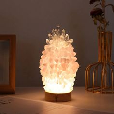 a light that is sitting on top of a table next to a vase with flowers in it