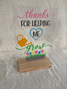 a clear acrylic sign that says thanks for helping me grow