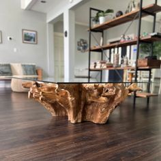 a wooden table sitting on top of a hard wood floor next to a living room