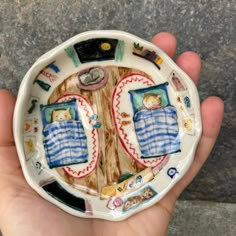 a hand holding a ceramic plate with two beds on it