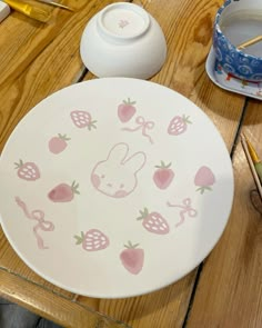 a plate with an image of a bunny on it and strawberries around the edge