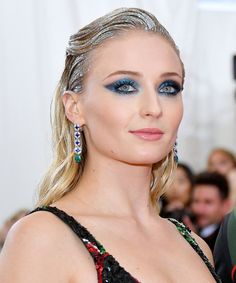 a woman with blue eyeshadow and black dress