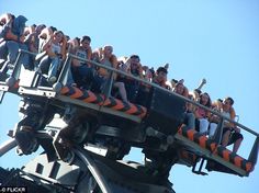 the roller coaster is full of people on it's sides and has orange seats