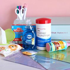 the contents of a personal care kit are displayed on a desk with scissors, toothpaste, and other items