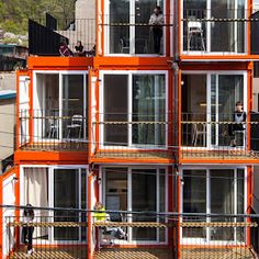 an orange and white building with people standing on the balconies