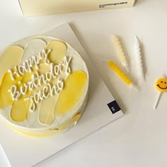 a birthday cake sitting on top of a white table next to some yellow and white decorations