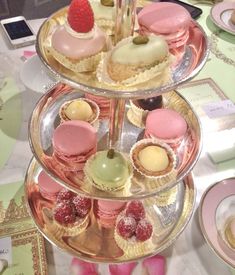 three tiered trays filled with different types of pastries on top of a table