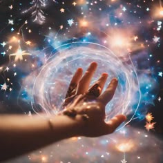 a person's hand holding a crystal ball with stars in the background