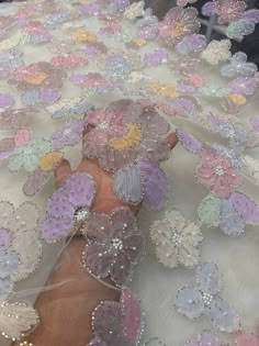 a woman's hand is covered with sequins and flowers