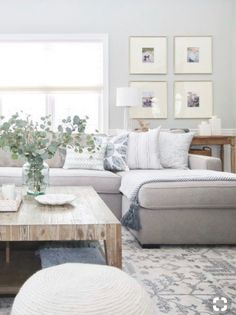 a living room with couches, tables and pictures on the wall in it's windowsill