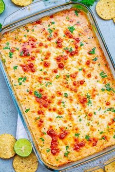 a casserole dish with cheese, tomatoes and cilantro on the side