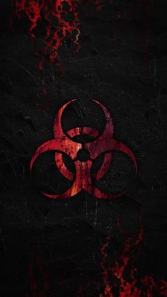 a red and black biohazard sign on the side of a dark surface with blood splatters all over it