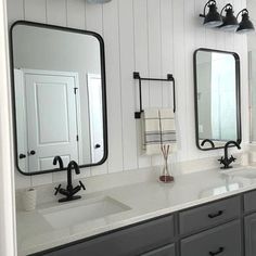 a bathroom with two sinks and three mirrors