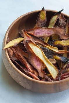 a wooden bowl filled with dried fruit on top of a table