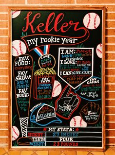 a chalkboard sign with baseballs and other sports related items on it in front of a brick wall