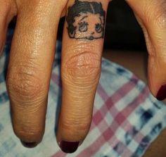 a person with a dog tattoo on their finger