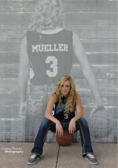 a woman sitting in front of a wall with a basketball