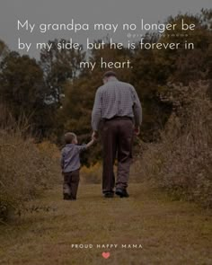 a man holding the hand of a little boy while walking down a path with trees in the background