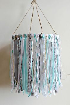 a blue and white chandelier hanging from the ceiling with beads on it's sides