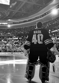 a hockey player standing on the ice in front of an arena full of people watching