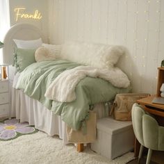 a white and green bedroom with lights on the wall above the bed, chair and desk