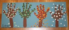 three handprinted trees on a blue background with white polka dots and green leaves