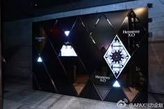 an advertisement for the company is lit up in front of a wall with geometric shapes