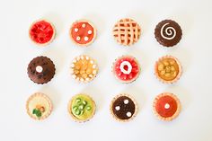 there are many different types of pastries on this white table top, including one with an apple in the middle