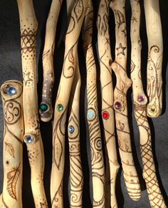 several wooden sticks with designs on them and colored stones in the middle one is painted