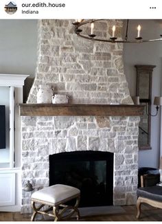 a living room with a fire place and a chandelier hanging from the ceiling