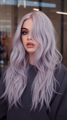 The platinum lavender hue enhances long, flowing waves with an ethereal and glamorous touch. This soft, cool tone is perfect for pale skin, creating a dreamy and modern look. Lilac Platinum Blonde Hair, Faded Lavender Hair, Platinum Lilac Hair, Silver And Lavender Hair, Blonde And Lavender Hair, Smokey Lavender Hair, White And Purple Hair, Purple Silver Hair, Grey Purple Hair