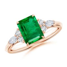 an emerald and diamond ring with three diamonds on the band, set in 18k rose gold