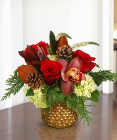 a vase filled with red and white flowers on top of a wooden table