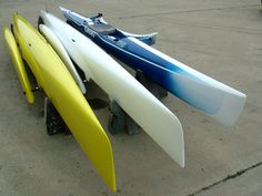 three surfboards are lined up next to each other on the concrete floor in front of a building