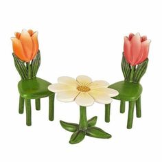 three plastic chairs with flowers on them sitting next to each other in front of a white background