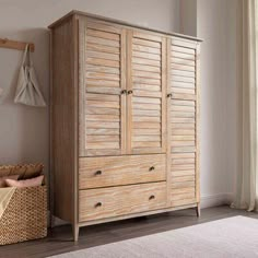 a wooden armoire sitting next to a basket on top of a carpeted floor