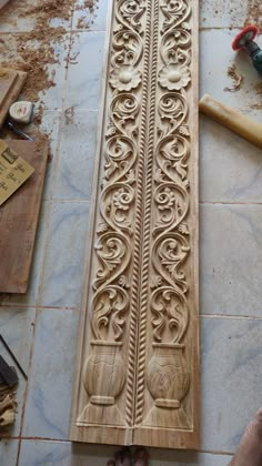 a person is working on an intricately carved wood paneling design in the process of being made