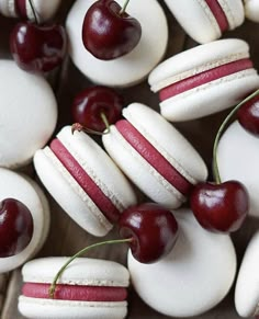 the macaroons are decorated with cherries and white icing, along with fresh cherries