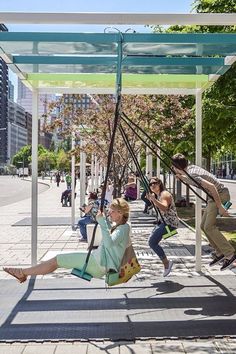 people are sitting on swings in the park