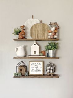 three shelves with various items on them in a living room or dining room, one has a sign that says pumpkin patch and the other is made out of wood