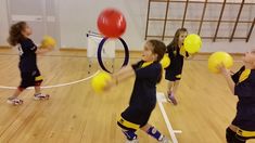 children are playing with yellow balls in an indoor gym