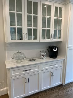 a kitchen with white cabinets and glass doors on the cupboards is pictured in this image