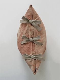 a piece of cloth wrapped in twine and tied with bows on a wall hanging