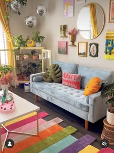 a living room with colorful rugs and pictures hanging on the wall above the couch