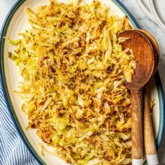 a white plate topped with coleslaw next to a wooden spoon